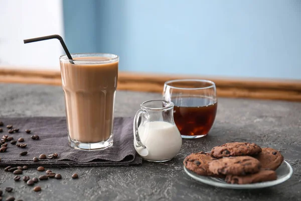Vaso de sabroso café frappe con leche y galletas sobre mesa gris —  Fotos de Stock