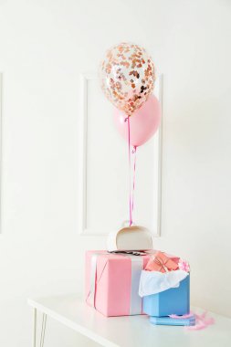 Beyaz duvar yakın masada Hava balonlar ile güzel hediyeler