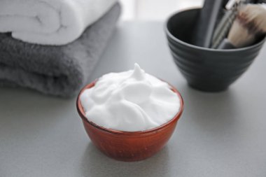 Gri masada tıraş köpüğü ile kase