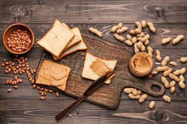 Ahşap arka planda lezzetli fıstık ezmesi ve ekmek ile Board