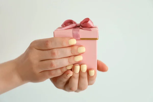 Female hands with gift box on light background — Stock Photo, Image