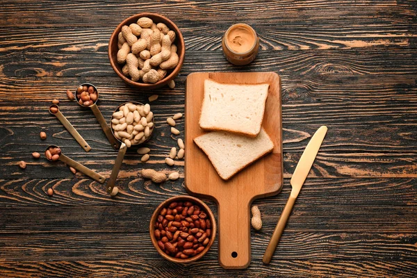 Bord met smakelijke pindakaas en brood op houten achtergrond — Stockfoto