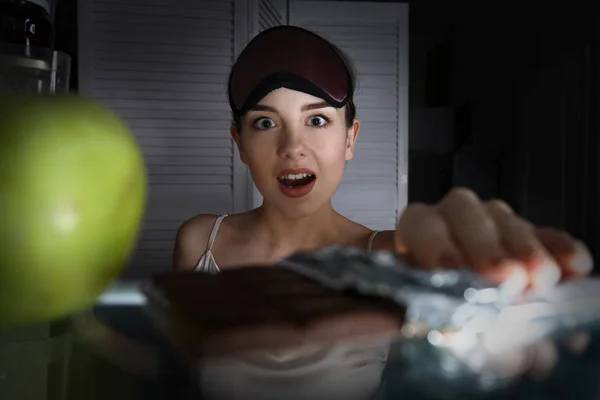 Emotional young woman choosing food in fridge, view from inside — Stock Photo, Image