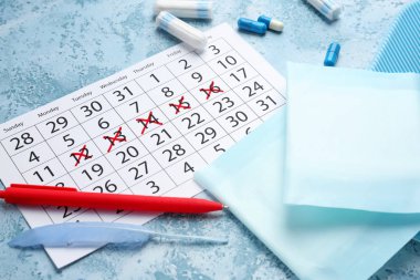 Kadınsı ürün ve renk arka plan üzerinde hapları ile adet takvim