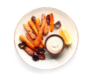 Beyaz arka planda lezzetli pişmiş havuç ve sos ile plaka