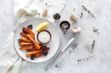 Gri masada lezzetli pişmiş havuç ve sos ile plaka