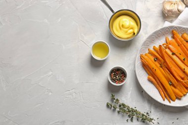 Gri masada lezzetli pişmiş havuç, sos ve baharatlar ile plaka