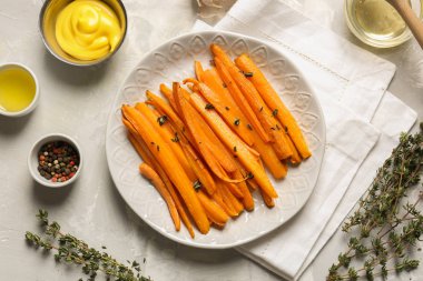 Gri masada lezzetli pişmiş havuç, sos ve baharatlar ile plaka