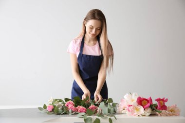 Çiçekçi ışık arka plana karşı masada buket yapma