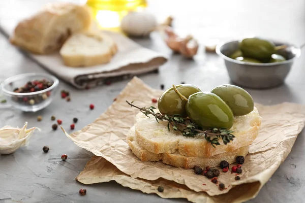 Olives savoureuses avec pain et épices sur table grise — Photo