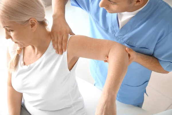 Physiotherapist working with mature patient in rehabilitation center — Stock Photo, Image