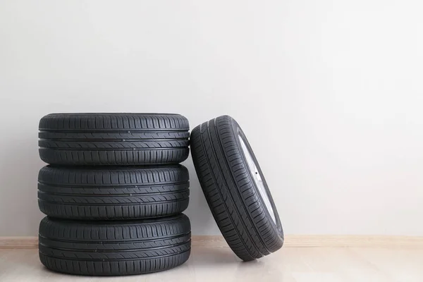 Neumáticos de coche cerca de pared blanca —  Fotos de Stock