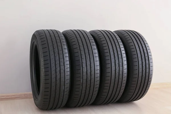 흰색 벽 근처의 자동차 타이어 — 스톡 사진