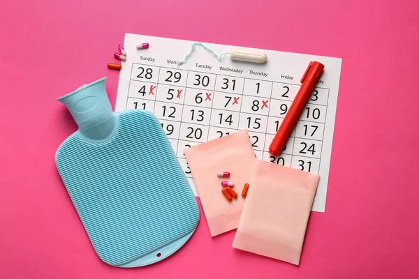 色の背景に女性の製品、水の袋と丸薬と月経カレンダー — ストック写真