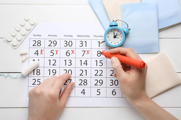 Woman marking her period in menstrual calendar — Stock Photo, Image