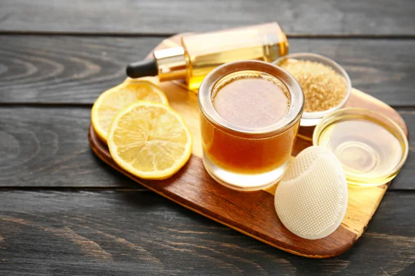 Sugar scrub with ingredients on wooden table