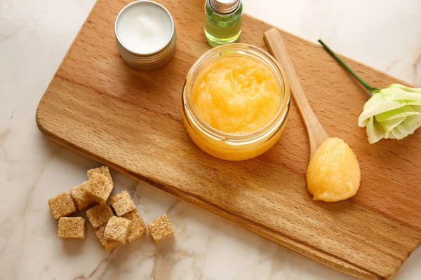 Jar with sugar scrub and cosmetic products on light table — Stock Photo, Image