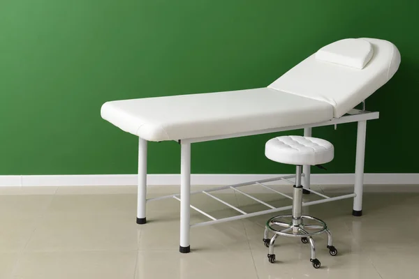 Léčebná pohovka se stoličkou poblíž barevné zdi — Stock fotografie