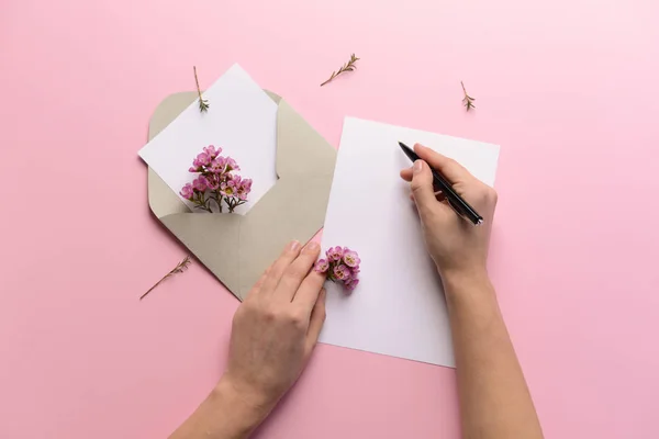 Female hands with empty invitation on color background — Stock Photo, Image