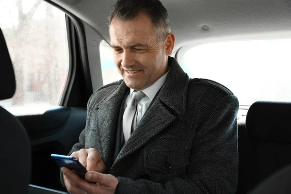 Bello uomo d'affari maturo con telefono in auto — Foto Stock