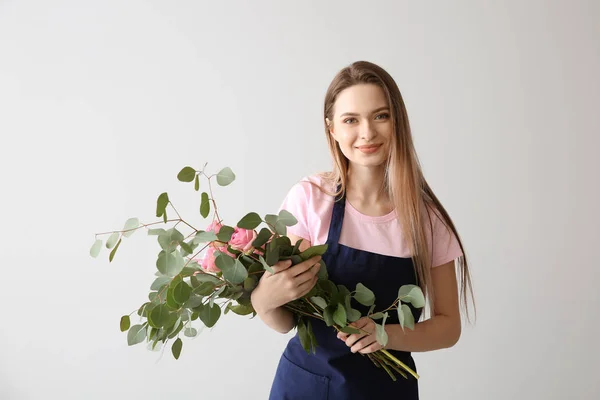 Florist with bouquet against light background — Stock Photo, Image