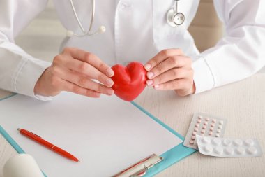 Klinikte masada kırmızı kalp ile kardiyolog