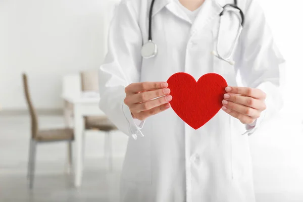 Cardiologist with red heart in clinic — Stock Photo, Image