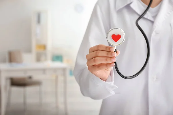 Klinikte kırmızı kalpli stetoskop tutan kardiyolog, yakın çekim — Stok fotoğraf