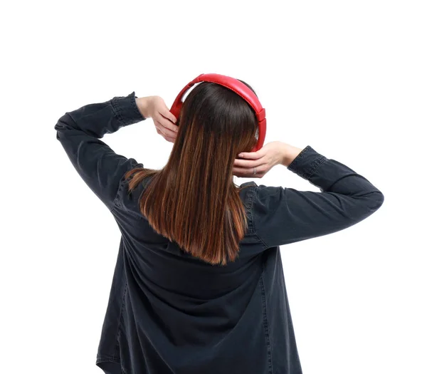 Mujer joven con auriculares escuchando música sobre fondo blanco —  Fotos de Stock