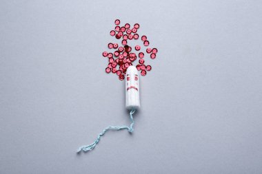 Hafif arka planda tampon ve kırmızı pullar. Menstrasyon konsepti