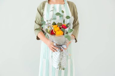 Hafif arka planda güzel buket tutan çiçekçi