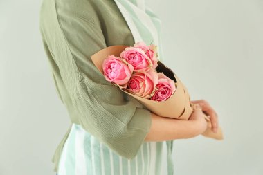 Hafif arka planda güzel buket tutan çiçekçi