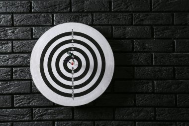 Koyu tuğla duvar üzerinde hit Bullseye ile dartboard