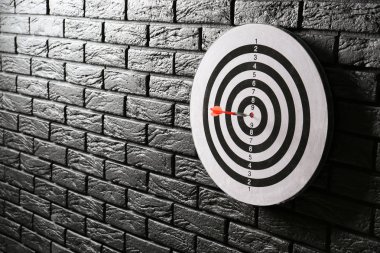 Koyu tuğla duvar üzerinde hit Bullseye ile dartboard