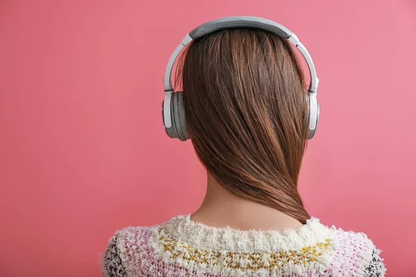 Jovem com fones de ouvido ouvindo música no fundo de cor — Fotografia de Stock