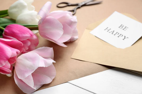 Vackra tulpaner och kort med text var lycklig på vitt bord — Stockfoto