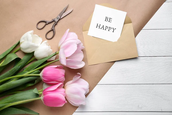 Vackra tulpaner, saxar och kort med text var lycklig på vitt bord — Stockfoto