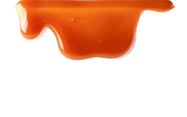 Fläckar av flytande karamell på vit bakgrund — Stockfoto