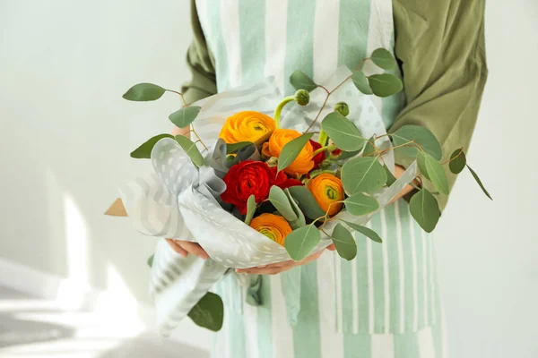 Florist hält schönen Strauß auf hellem Hintergrund — Stockfoto