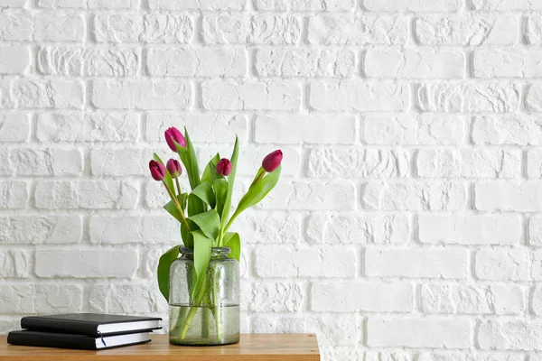 Ваза з красивими тюльпанами і книгами на столі — стокове фото
