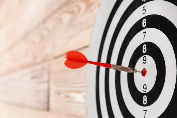 Dartbord met klap bullseye op houten muur, close-up — Stockfoto