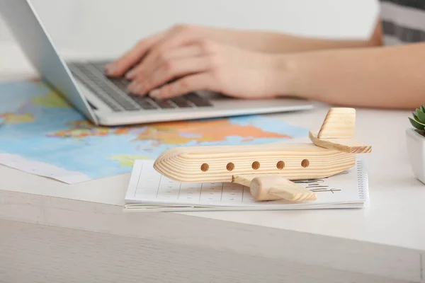 Toy airplane and calendar on table of travel agent in office — Stock Photo, Image