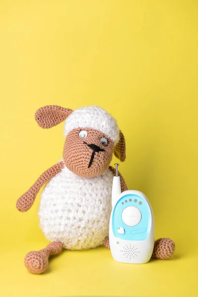 Modern baby monitor with toy on color background — Stock Photo, Image