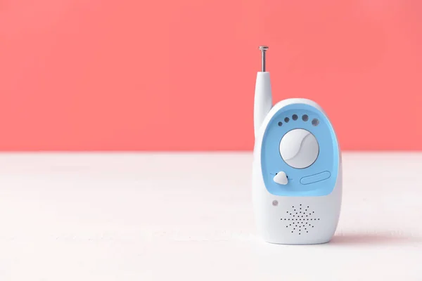 Modern baby monitor on table against color background — Stock Photo, Image