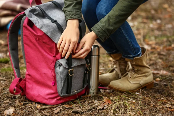 Жінка з рюкзаком і термос подорожує в лісі — стокове фото
