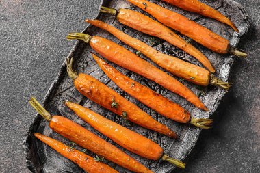 Gri masada lezzetli pişmiş havuç ile plaka