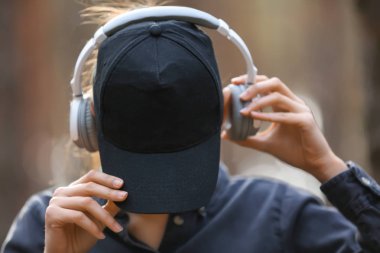 Genç kadın açık havada müzik dinlerken yüz gizleme