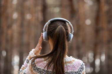 Genç kadın ormanda müzik dinlemek