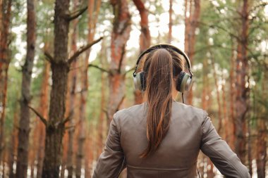 Genç kadın ormanda müzik dinlemek