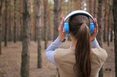 Genç kadın ormanda müzik dinlemek